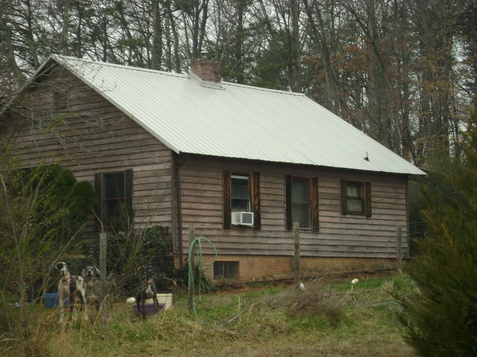 White metal roof on an old wood sided farmhouse, from a Metal Roof Installation job in Lanark